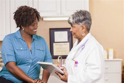 Doctor Conducts Medical Consultation With Adult Patient At Clinic Harbor Health Services