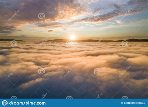 Aerial View Of Vibrant Sunset Over White Dense Clouds With Distant Dark