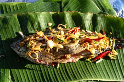 Wrap and tie each package. Victoria Phan Thiet - Grilled Fish in Banana Leaf - Image ...