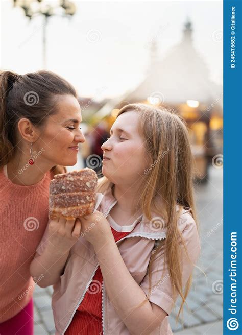 Happy Modern Mother And Child At Fair In City Eating Trdelnik Stock