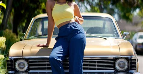 Photo Of Woman Posing While Leaning On Hood Of Parked Car · Free Stock