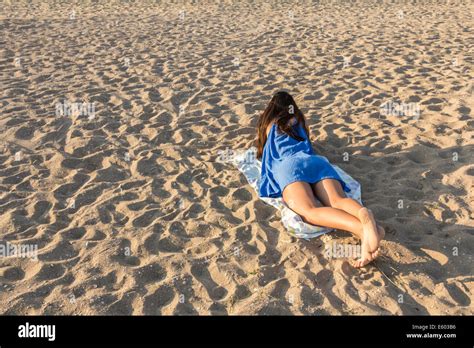 Rear View Of Pretty Girl Lying On Sandy Beach On Hot Summer Stock Photo