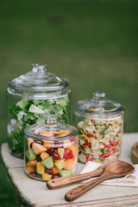 Three Glass Jars Filled With Food Sitting On Top Of A Wooden Table Next