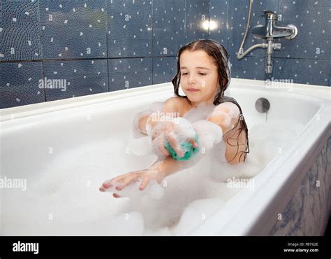 Little Girl Washing Her Hand With Sponge Sitting In The Bath Closeup