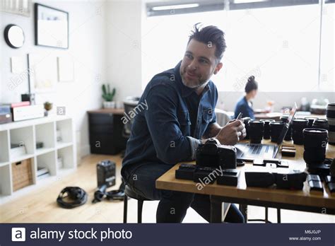 Smiling Male Photographer With Equipment Working In Office Stock Photo