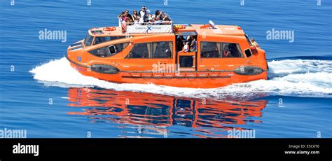 Lifeboat Tender And Cruise Ship Passengers Being Ferried Between Off Shore Anchorage Towards