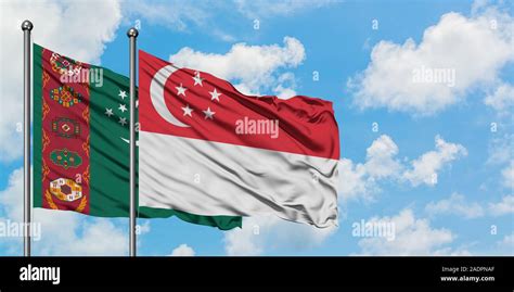 Turkmenistan And Singapore Flag Waving In The Wind Against White Cloudy