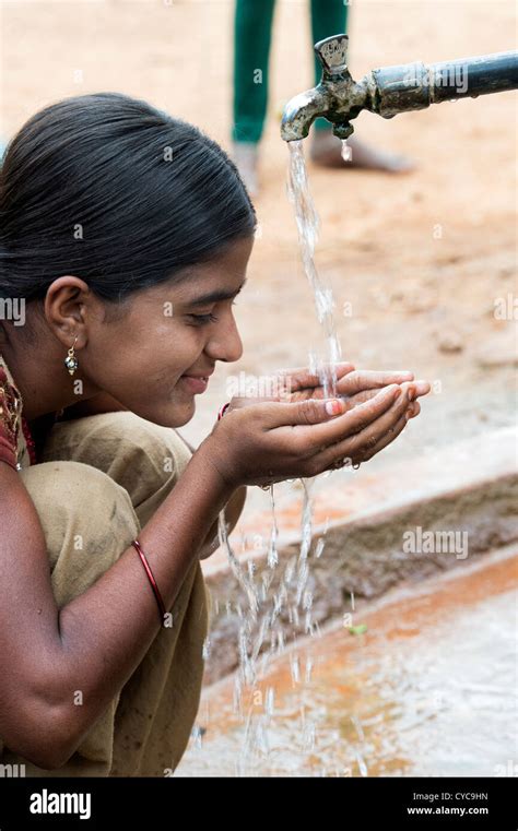 Indian Girl Drinking From A Communal Water Tap In Rural Indian Village