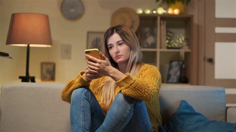 Tired Girl Sitting On Sofa With Cell Phone Stock Footage Sbv Storyblocks