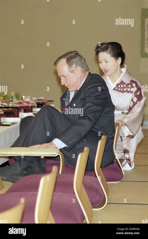 U S President George Bush Squeezes In His Legs To Sit At A Japanese Style Table During A