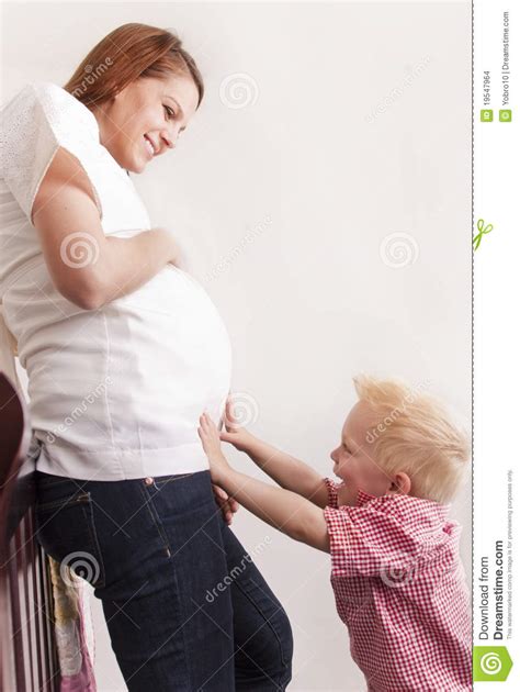 Mujer Embarazada Que Juega Con Su Hijo Joven Foto De