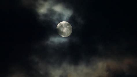 Full Moon Hiding By The Clouds On Dark Night Sky