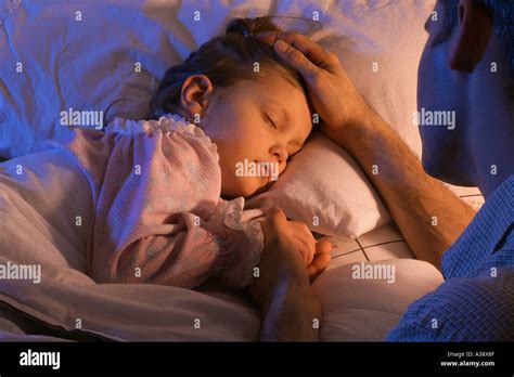 Father Beside Sleeping Daughter Bed Stock Photo Alamy