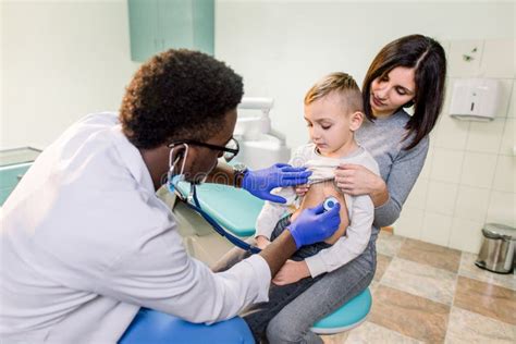 Portrait Of A Little Boy Being Checked By A Doctor Using A Stethoscope