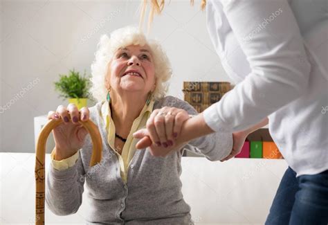 Verpleegkundige Helpt Bejaarde Vrouw Opstaan — Stockfoto © Grinvalds