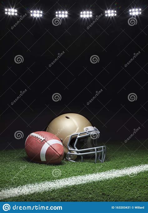 A Gold Football Helmet And Football On A Grass Field With Stripe On