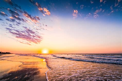 Colorful Beach Sunrise Or Sunset Along The Ocean Shore Stock Photo