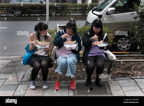 Three Japanese Girls Eating Junk Food On Omotesando Street Tokyo Japan Asia Female Friends