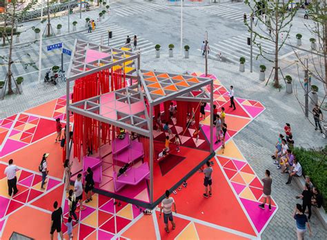 People Are Walking Around An Art Installation In The Middle Of A City