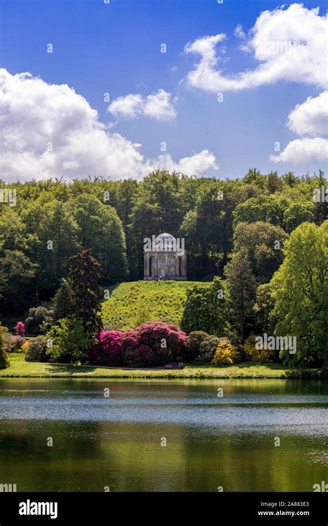 The Circular Temple Of Apollo Looks Out Over Colourful Rhododendron