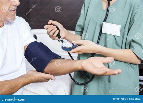 Midsection Of Nurse Checking Blood Pressure Of Patient Stock Image