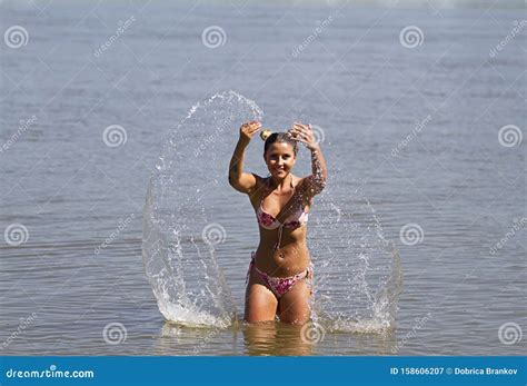 Cute Blonde In A Bikini In The Water It Is Sprayed With Water