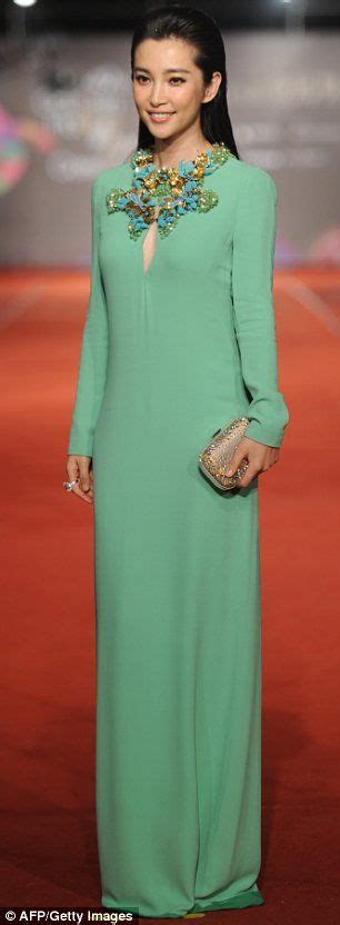 A Woman In A Long Green Dress On A Red Carpet With Her Hand On Her Hip