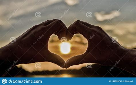 Heart Gesture In Front Of Sunset Above River Water Surface Defocused