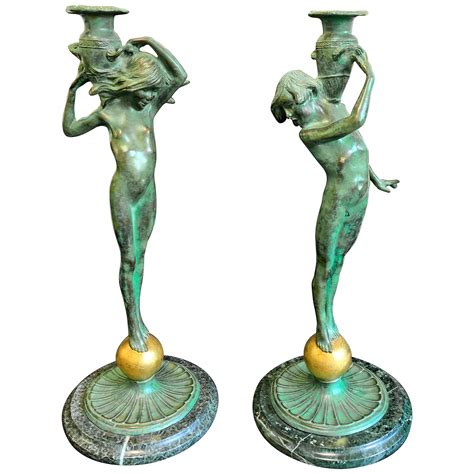rare porcelain candlesticks featuring nude maidens with copper colored