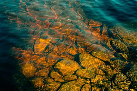 Фото Камни с чистой водой в лучах солнца озера на дне