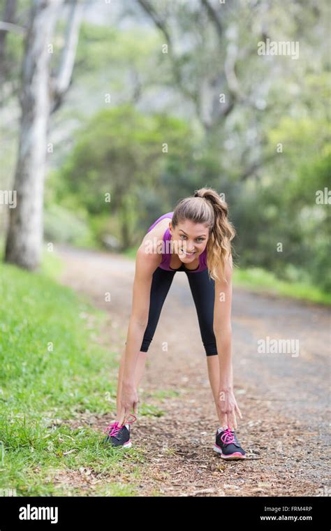 Young Woman Bending On Footpath Stock Photo Alamy