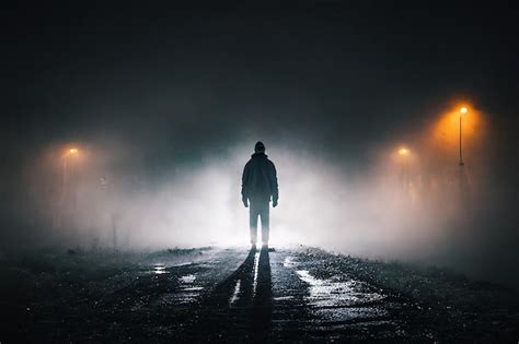 Premium Photo A Man Walking In The Fog On The Road Foggy Night