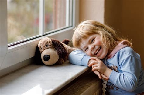 Cute Toddler Girl Sitting By Window And Looking Out Dreaming Child