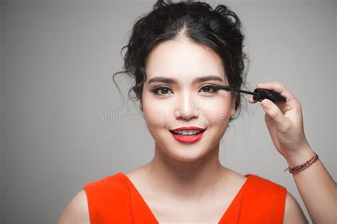 Beautiful Young Asian Woman Doing Makeup Using Mascara On Her Eyelashes