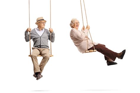 Full Length Shot Of Elderly Man And Woman On Wooden Swings Stock Photo