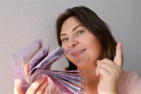 Elderly Woman Happily Holds In Her Hand A Large Pile Of Euro Banknotes