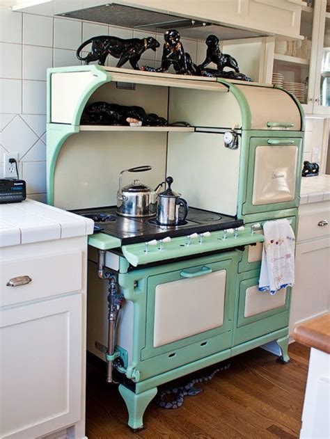An Old Fashioned Green Stove Top Oven Sitting In A Kitchen Next To A