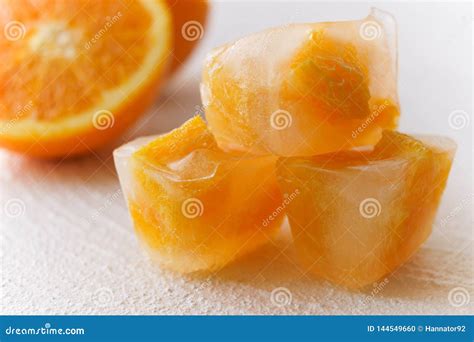 Orange Fruit Frozen In Ice Cubes Close Up White Background Stock