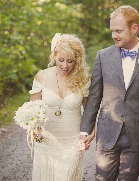 A Bride And Groom Walking Down A Path Holding Hands