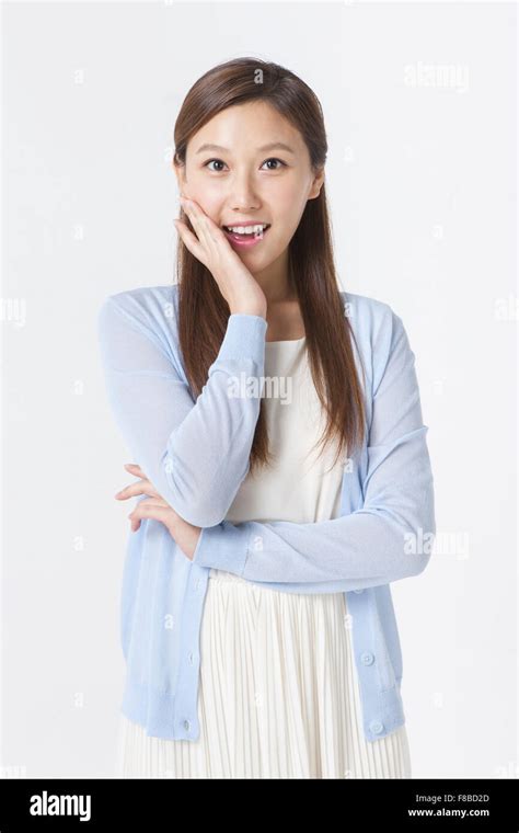 Woman In White Dress And Blue Cardigan Staring Forward With Her Hand On