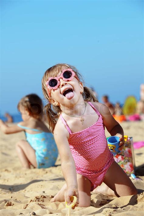 Glad barn der leger med sand på stranden om sommeren Stock foto