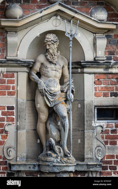 A Statue Of Poseidon Standing In A Niche With His Trident At