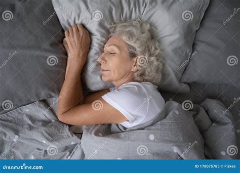 Happy Mature Woman Sleeping On Soft Pillow Under Blanket Stock Image