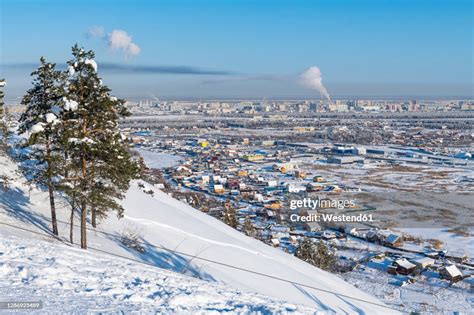 Russia Republic Of Sakha Yakutsk Snowcapped Hill With City Houses In