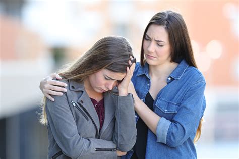 Worried Woman Comforting Her Sad Friend In The Street Stock Photo