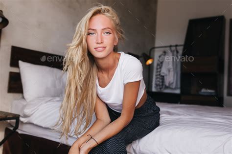 Lightly Tanned Cute Woman With Long Hairstyle Sitting On Bed Refined