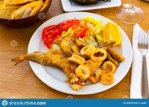 Fried Seafood Delicacies With Fresh Vegetables And Lemon Stock Photo