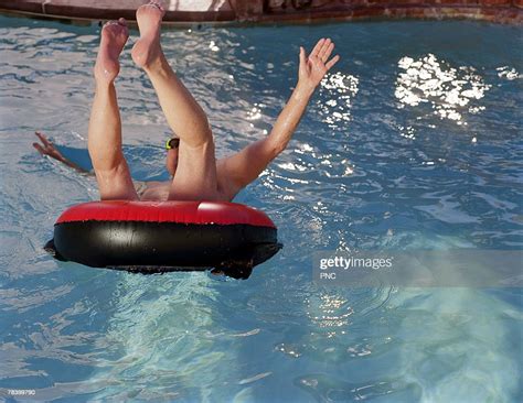Man Jumping Into Pool In Innertube Photo Getty Images