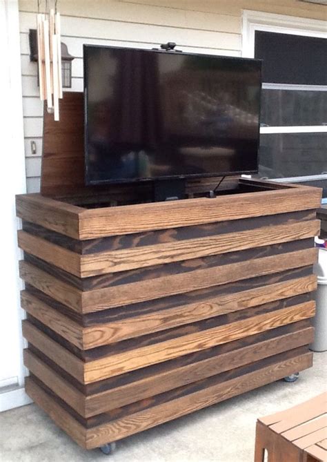 A Flat Screen Tv Sitting On Top Of A Wooden Cabinet In Front Of A House