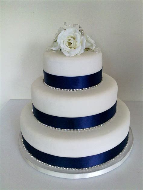 Start by asking how many people the couple is expecting at the reception and first, add any decoration that will be easier to do while the tiers are separate, such as adding ribbon to the bottom or decorating the sides. Navy Wedding Cake Decorations | Wedding Ideas By Colour | CHWV